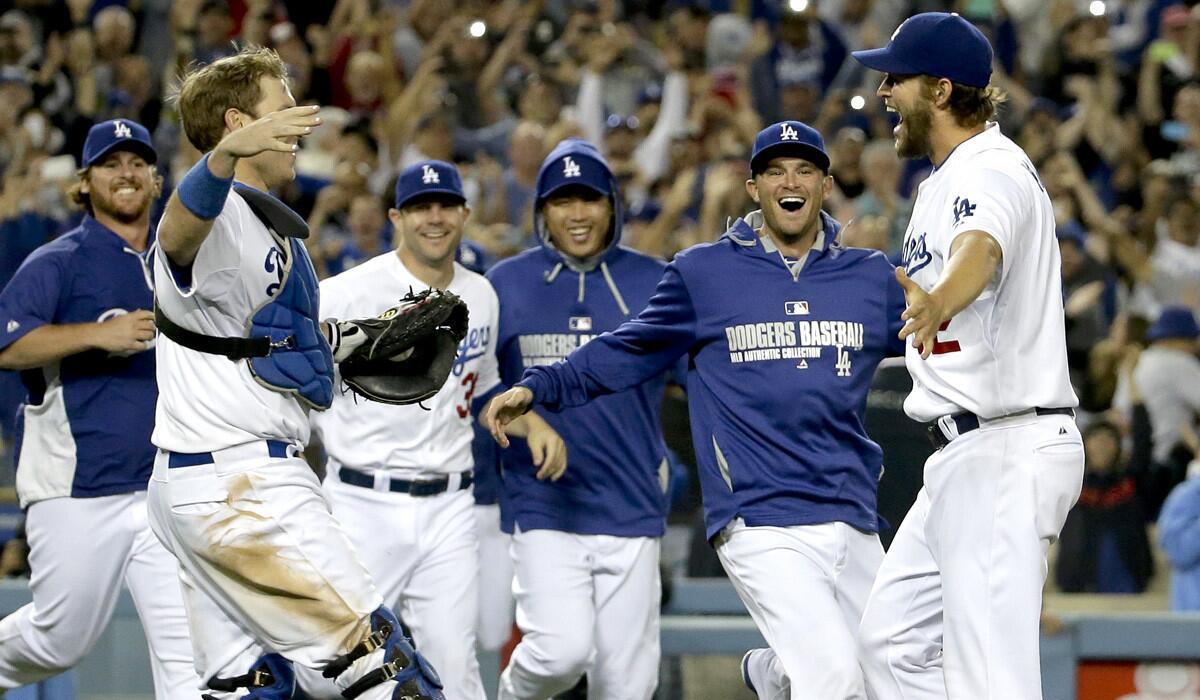 Dodgers starting pitcher Clayton Kershaw, right, is swarmed by teammates after completing his no-hitter against the Colorado Rockies on Wednesday night at Dodger Stadium.