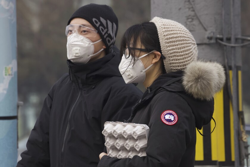 Residents wear protective masks on a Beijing street.