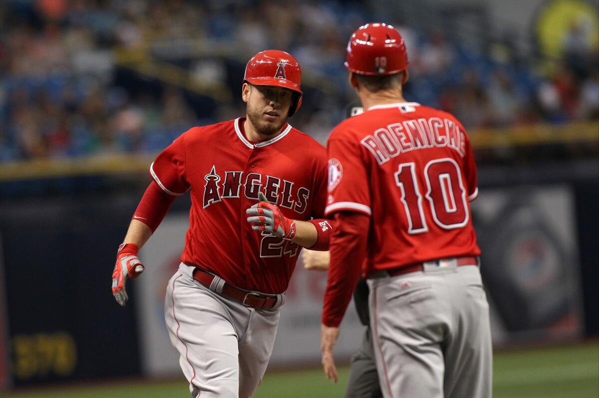 Angels first baseman C.J. Cron is greeted by third base coach Ron Roenicke after hitting the first of two home runs against Tampa Bay.