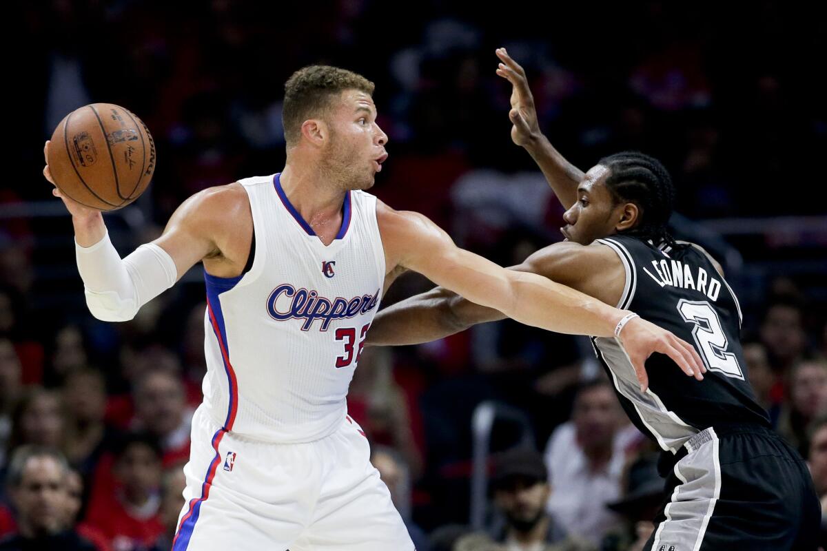 Blake Griffin passes around San Antonio forward Kawhi Leonard during Game 2 of the Clippers-Spurs playoff series at Staples Center on April 23.