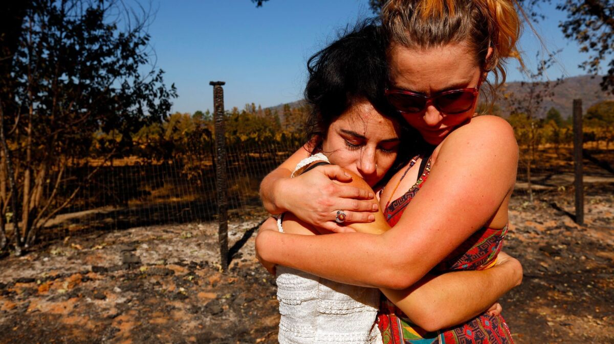 Ashley Oldham, owner of Frost Flower Farms, left, receives a hug of support from friend Serena Inda in Redwood Valley.