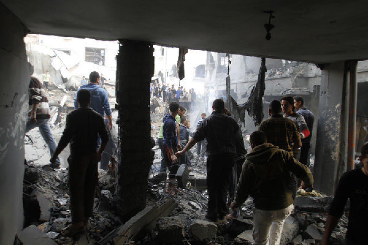Palestinians stand in the rubble of the Dalu family's house in Gaza after an Israeli air strike. Ten members of the family -- six women and four children -- were killed in the strike, which a new report from Israel's military says was a mistake.
