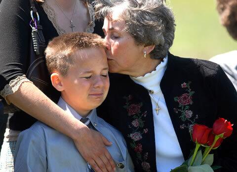 Trevor Oliver, 11, is comforted by his grandmother Elaine Atkins during the funeral Tuesday for his father, Army Staff Sgt. Travis Atkins, in Bozeman, Mont. Atkins, whose parents said he had survived two previous roadside bomb attacks, was killed June 1 by a suicide bomber in Al Yusufiyah, Iraq. Atkins was the first soldier from Bozeman to be killed in Iraq.