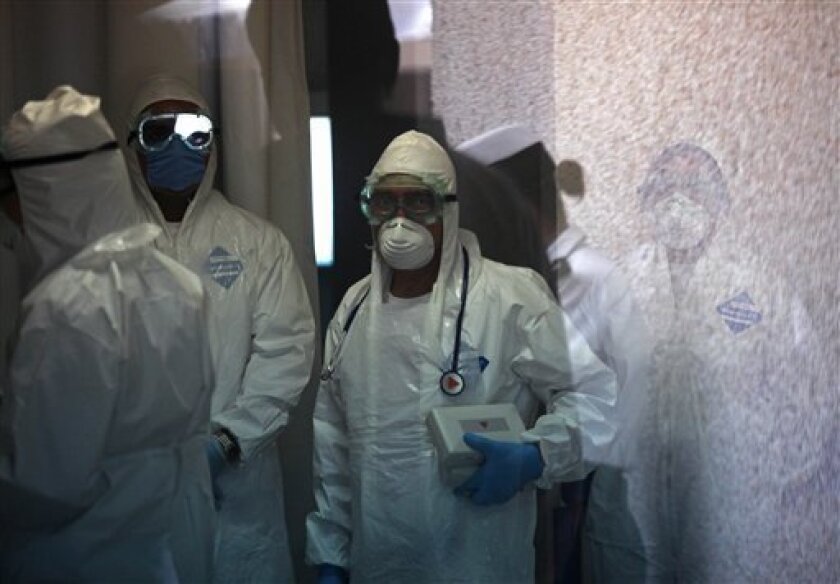 Medics wearing protective gear work at the emergency area where people with swine flu-like symptoms are checked at the Naval hospital in Mexico City Friday May 1, 2009.(AP Photo/Brennan Linsley)