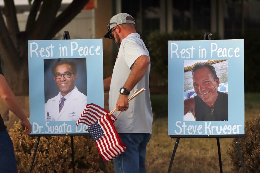 Flags are placed near photos of Dr. Sugata Das and UPS driver Steve Krueger in Santee on Oct. 14.