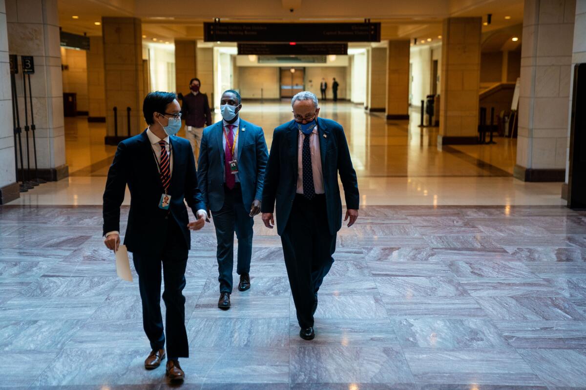 Sen. Charles E. Schumer accompanied by two staff members