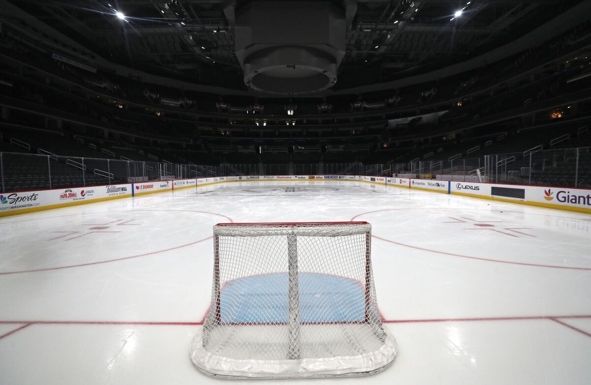 View from behind the net of an empty hockey rink.