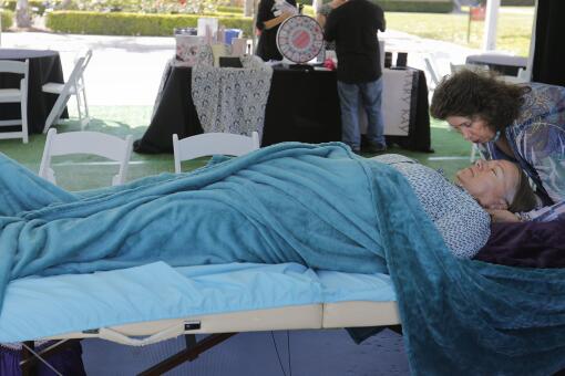 SAN DIEGO, CA 6/9/2018: Linda White, right, works with Kathy Hamman of Oceanside at the Integrative Core Healing booth in the Pamper Pavilion at CaregiverSD held in Liberty Station. Photo by Howard Lipin/San Diego Union-Tribune/Mandatory Credit: HOWARD LIPIN SAN DIEGO UNION-TRIBUNE/ZUMA PRESS