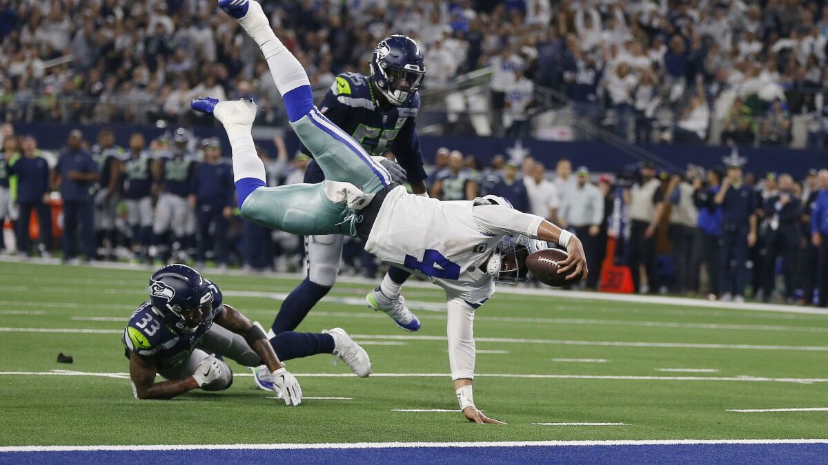 Dallas Cowboys quarterback Dak Prescott (4) flies for the goal line and gets a first down against the Seattle Seahawks during the second half of the NFC wild-card game in Arlington, Texas.