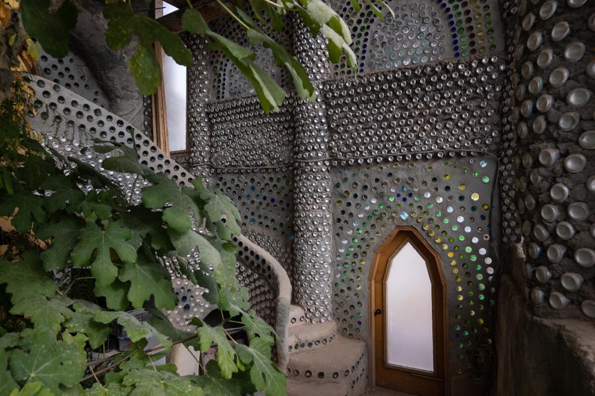 Glass bottles and aluminum cans inside Earthship walls resemble mosaic works.