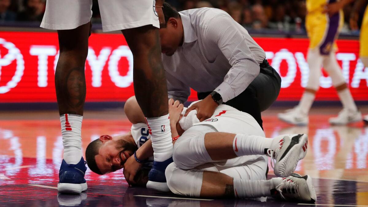 A trainer tends to Clippers guard Austin Rivers after he injured against the Lakers in the first half at Staples Center on Dec. 29, 2017.