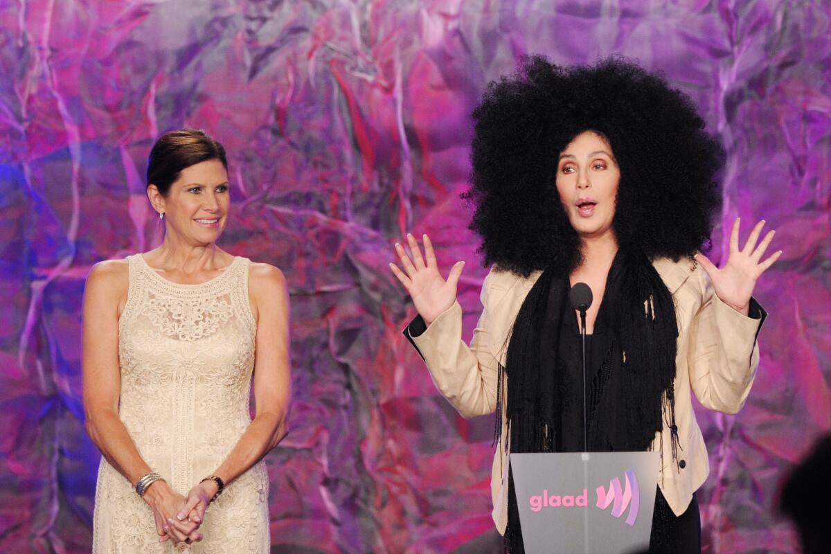 Two women stand onstage to accept an award.