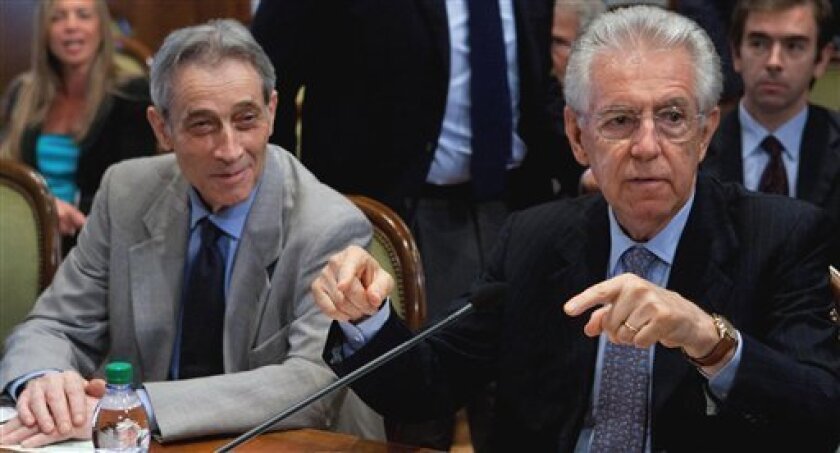 Italian Premier Mario Monti, right, flanked by Enrico Bondi gestures during a meeting to outline details on the spending review in Rome, Tuesday, July 3, 2012. Bondi has the task of deciding what cuts are carried out in which ministries. Bondi is the Italian turnaround expert who helped restructure the Parmalat dairy empire after its collapse in fraudulent bankruptcy last decade. (AP Photo/Roberto Monaldo, Lapresse)