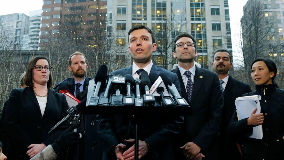 Washington state Solicitor General Noah Purcell, center, addresses reporters about the state's lawsuit against the Trump administration following a hearing in federal court in Seattle on Feb. 3.