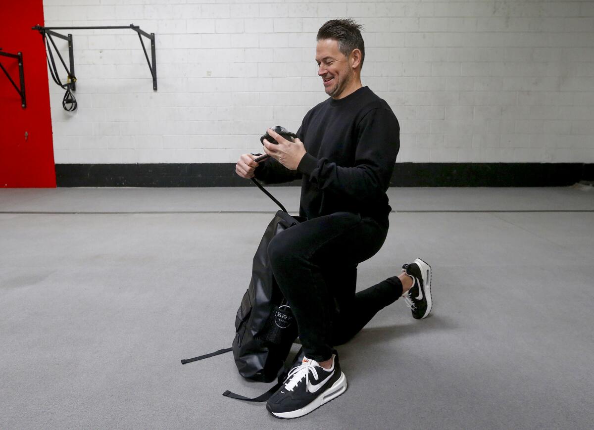 Paul Norris, who runs Surf Ready Fitness in Costa Mesa, demonstrates the equipment bundle that he launched last year.