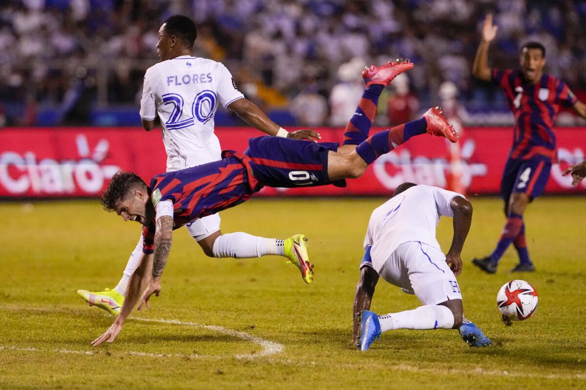 El delantero estadounidense Christian Pulisic (10) salta sobre el hondureño Maynor Figueroa 