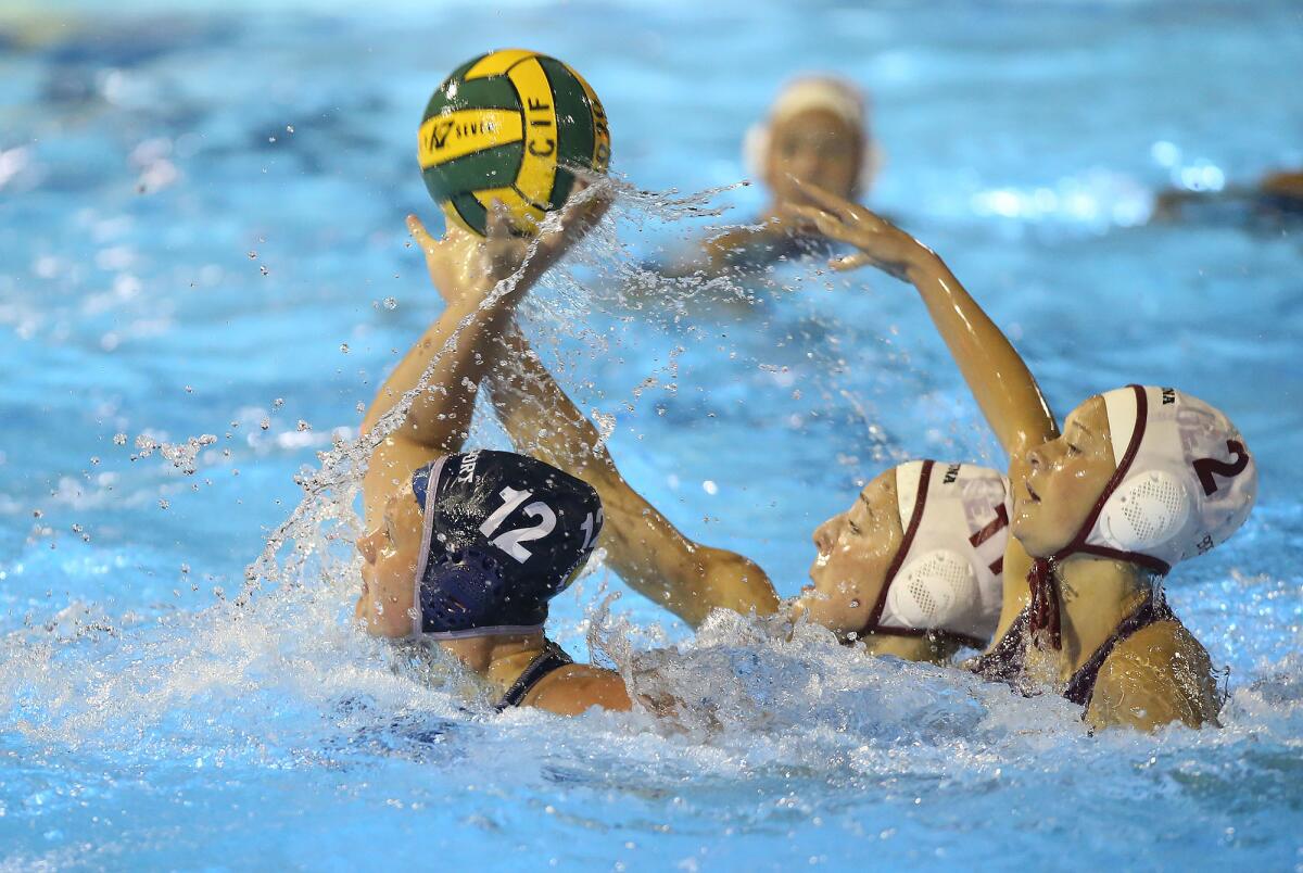 Newport Harbor’s Olivia Giolas (12) tries to get a shot off as Laguna Beach’s Emma Singer (11) and Morgan Van Alphen (2) close in during the semifinals of the CIF Southern Section Division 1 playoffs on Feb. 19.