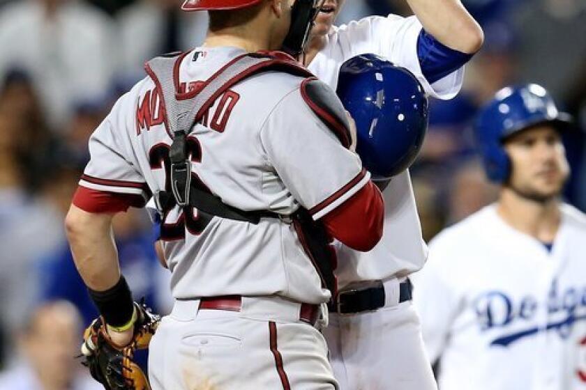Zack Greinke and Miguel Montero talk at the plate after the Dodgers' starter was hit by an Ian Kennedy pitch in the seventh inning of the Dodgers' 5-3 victory over the Diamondbacks.