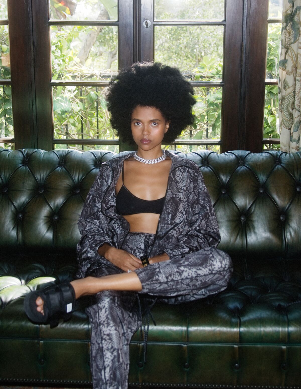 A model wearing a snakeskin-print windbreaker and pants.