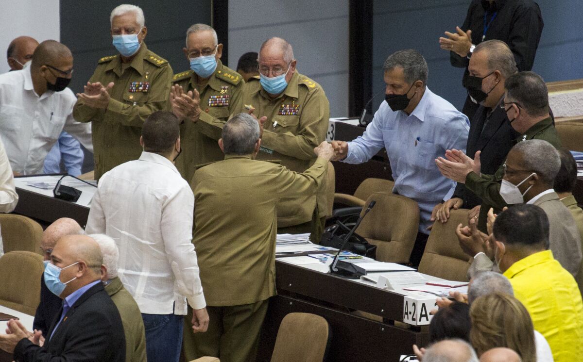 In this photo released by Cubadebate, Gen. Luis Alberto Rodriguez Lopez-Calleja, right, greets former Cuban President Raul Castro at the National Assembly in Havana, Cuba, Dec. 21, 2021. Lopez-Calleja, one of the most trusted advisers to Castro and head of the country's military business division, died on July 1, 2022 at age 62. The Communist Party and official news media said he died of a cardiopulmonary arrest. (Irene Perez/Cubadebate via AP)