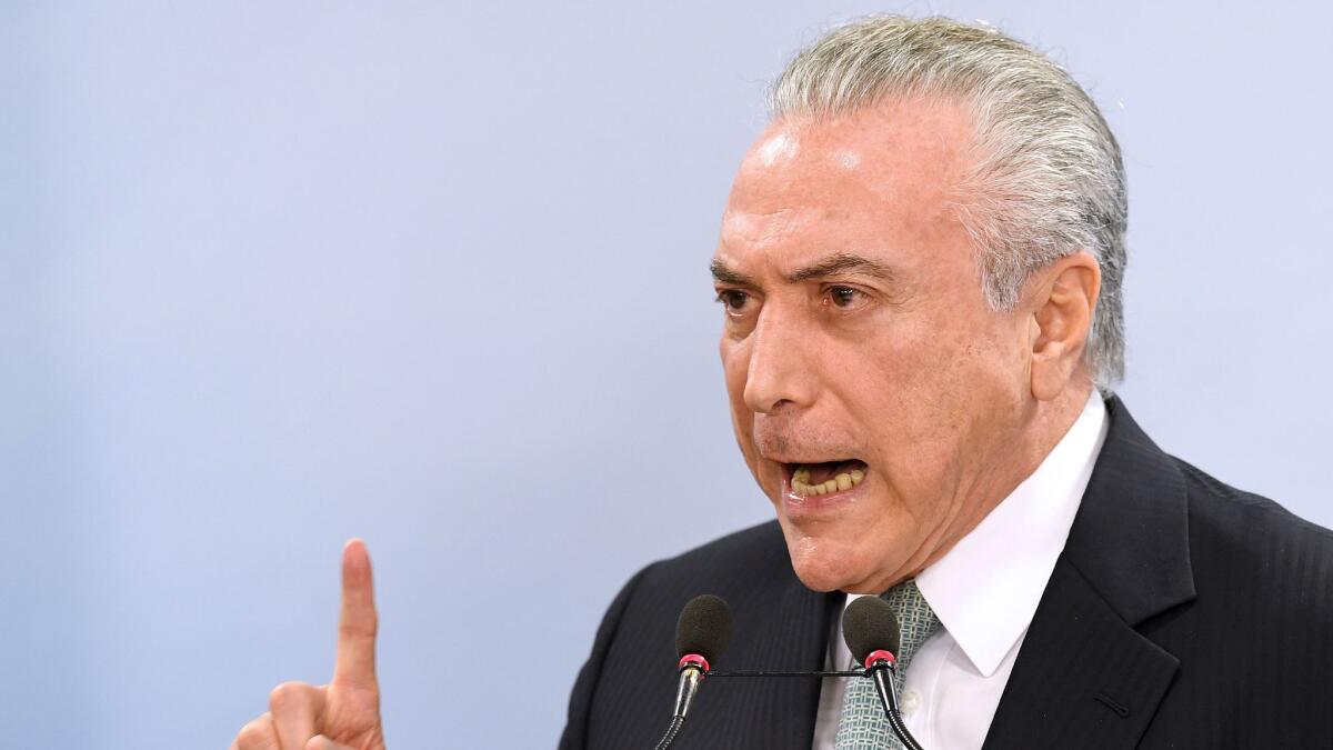 Brazilian President Michel Temer speaks at a press conference following allegations that he gave his blessing to payment of hush money to a politician convicted of corruption.