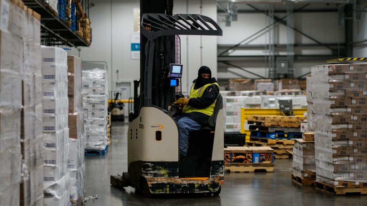 A worker, bundled up against the chill, moves inventory at a Lineage Logistics cold storage warehouse in Vernon.