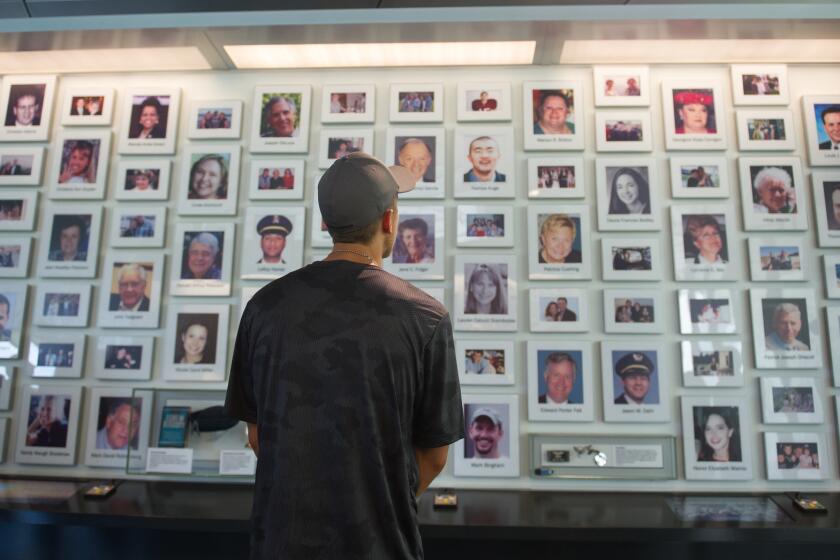 A visitor at the Flight 93 National Memorial in Shanksville, Pa., looks through the portraits of the passengers and crew who died when the hijacked plane crashed on Sept. 11, 2001.