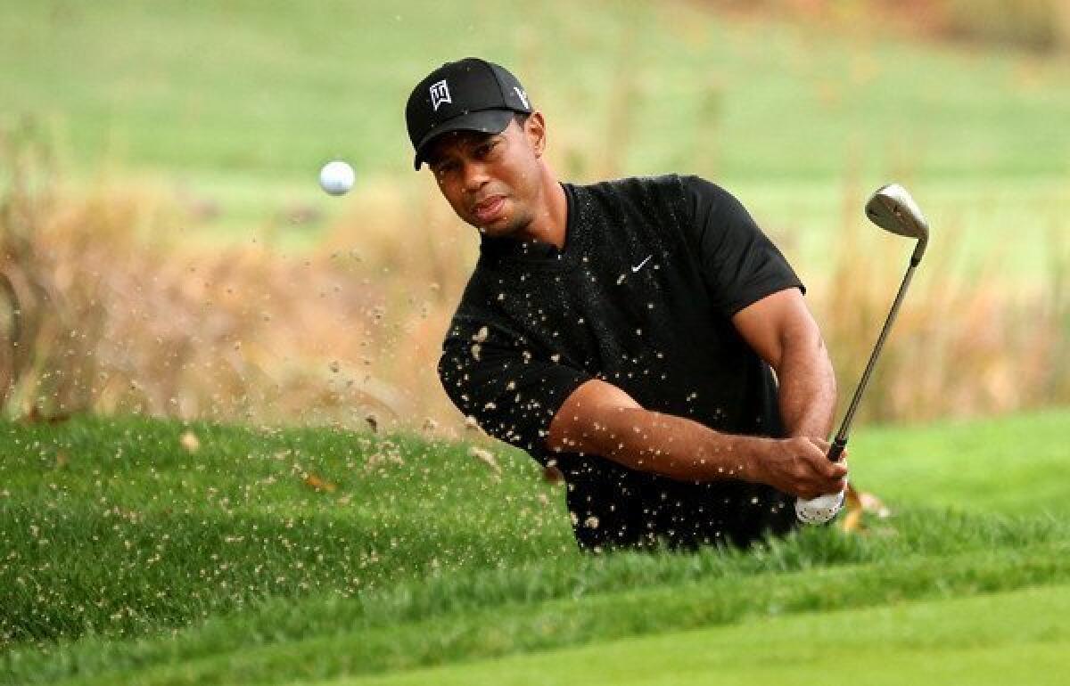 Tiger Woods hits out of a bunker at No. 4 on Saturday during the third round of the World Challenge at Sherwood Country Club in Thousand Oaks.