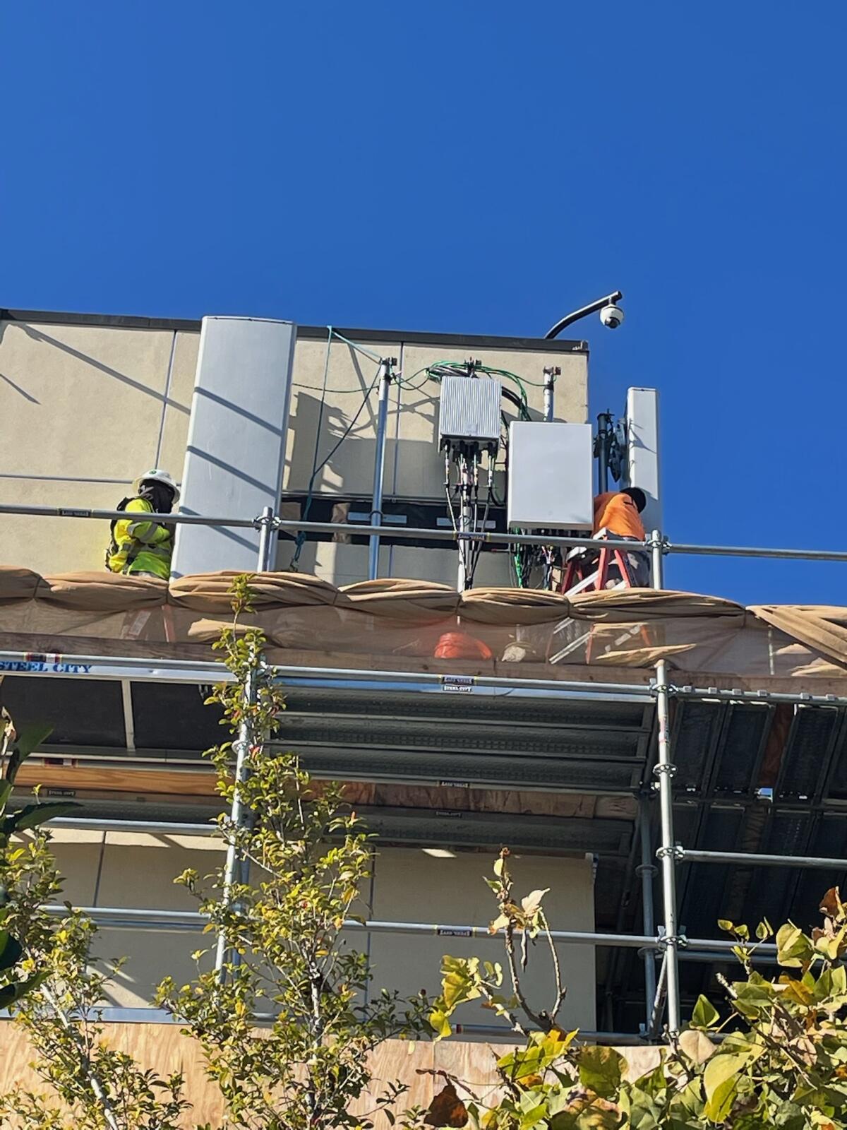 Workers install wireless network equipment on the Rock Academy property at Liberty Station in January.