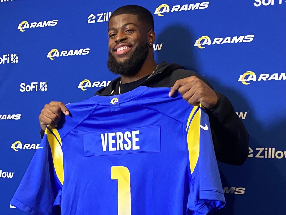 Rams first-round draft pick holds up a jersey during his introductory media conference.