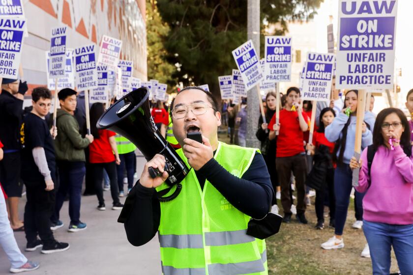LOS ANGELES-CA - NOVEMBER 14, 2022: Alex Chubick, a student researcher in the human genetics department, leads fellow demonstrators in a chant at UCLA as nearly 48,000 University of California academic workers strike on Monday, November 14, 2022, in a labor action that could shut down some classes and lab work just weeks before final exams. Chubick is getting ready to graduate but says it's important to be here today to fight for new students coming in. (Christina House / Los Angeles Times)