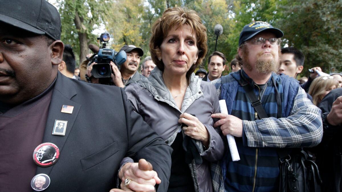 Former UC Davis Chancellor Linda Katehi is escorted from the stage after speaking at a campus rally in 2011 about an incident in which police doused peaceful demonstrators with pepper spray during a protest.