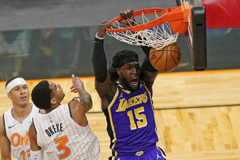 Los Angeles Lakers center Montrezl Harrell (15) dunks the ball over Orlando Magic forward Chuma Okeke (3) but was called for traveling and the basket did not count during the first half of an NBA basketball game, Monday, April 26, 2021, in Orlando, Fla. (AP Photo/John Raoux)