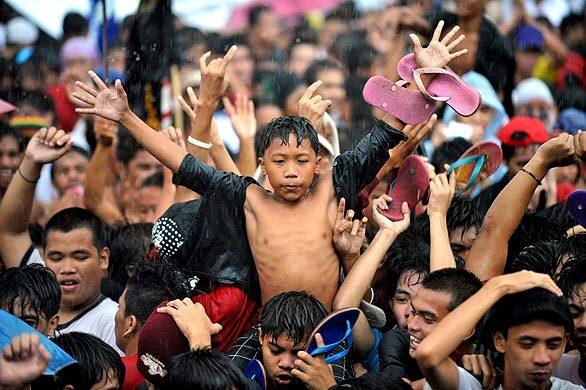 Rain-drenched protesters dance during an anti-government rally in Manila, Philippines, where President Gloria Arroyo prepared to deliver her last state of the nation address before elections next year. Arroyo, who came to power in 2001 following the ousting of Joseph Estrada, was expected to use the speech to outline her accomplishments during her tumultuous tenure, which has been marked by scandal and failed coup attempts.