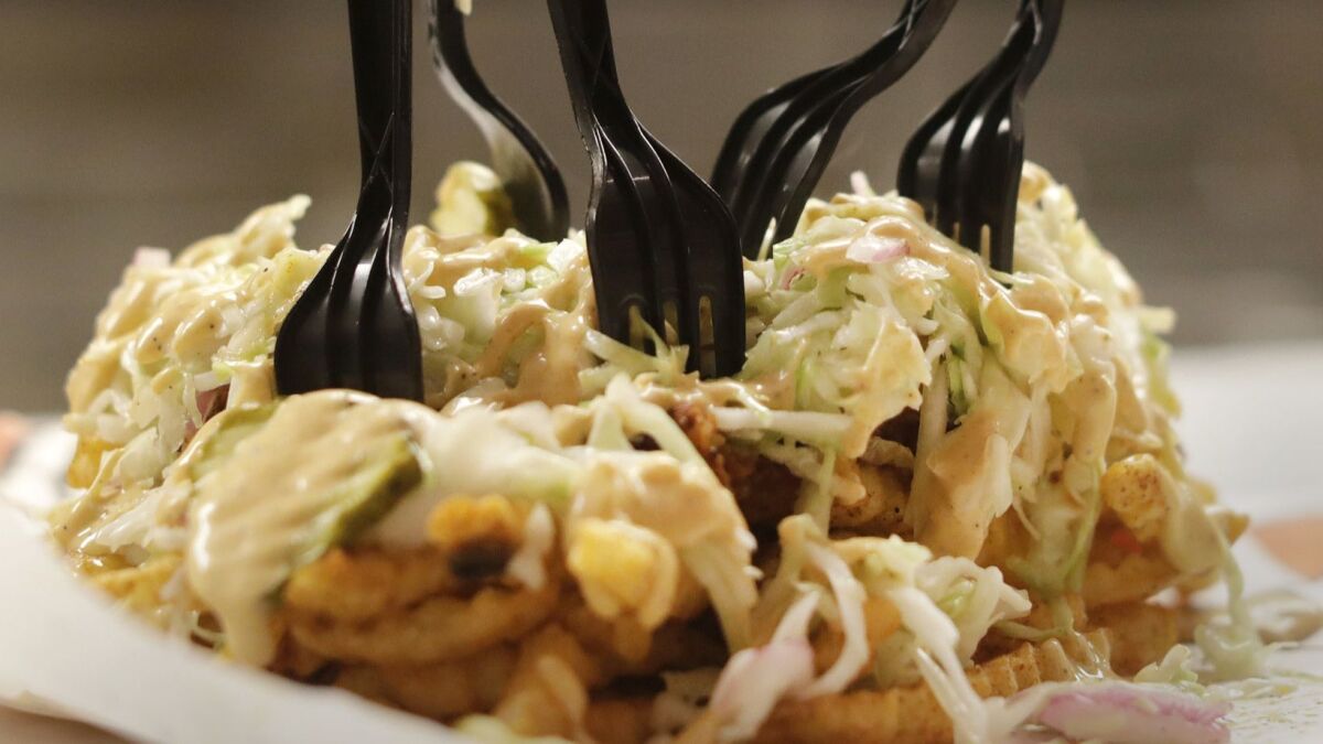 An off-the-menu item at Howlin' Ray's: Mario fries are French fries topped with chicken, cole slaw, pickles and cheese.