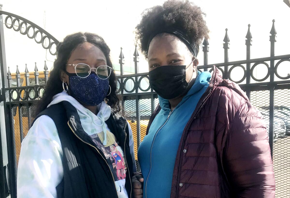 Poll workers Patrice Taylor and Tracy Armstrong, in masks, outside a Detroit vote center.