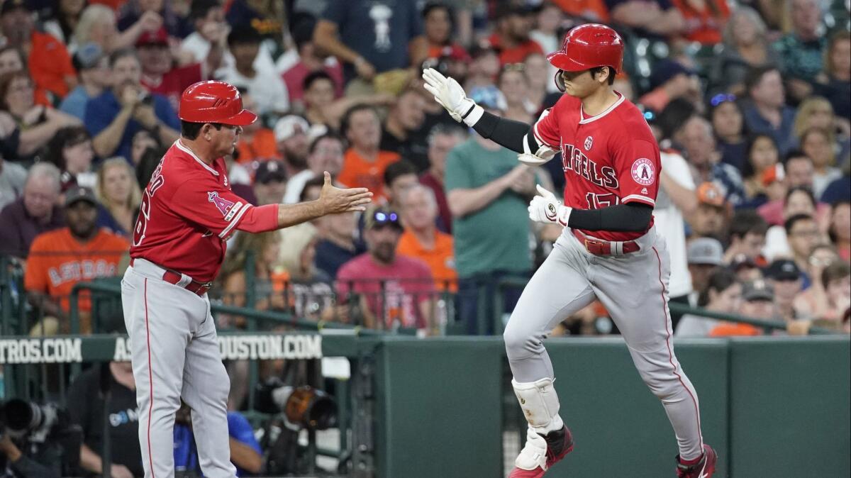 The Angels' Shohei Ohtani is congratulated by third base coach Mike Gallego after connecting for a third-inning home run against the Astros on Friday night.