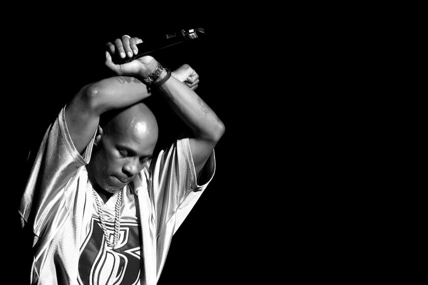 DMX raising his arms above his head in an X formation