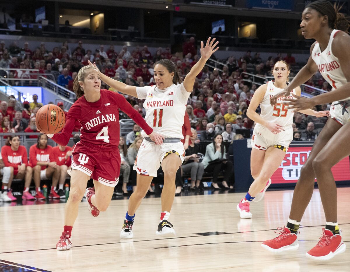 Indiana guard Nicole Cardano-Hillary (4) passes around as Maryland guard Katie Benzan (11) defends during an NCAA college basketball game in the Big Ten conference tournament, Friday, March 4, 2022, at Gainbridge Fieldhouse in Indianapolis. (Robert Scheer/The Indianapolis Star via AP)