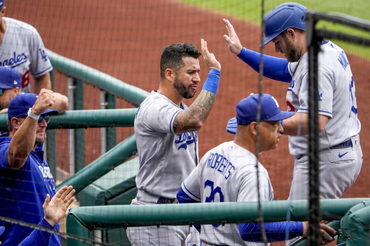 The Dodgers' Max Muncy (right) high-fives after he scored on a single by Jason Heyward in the first inning.
