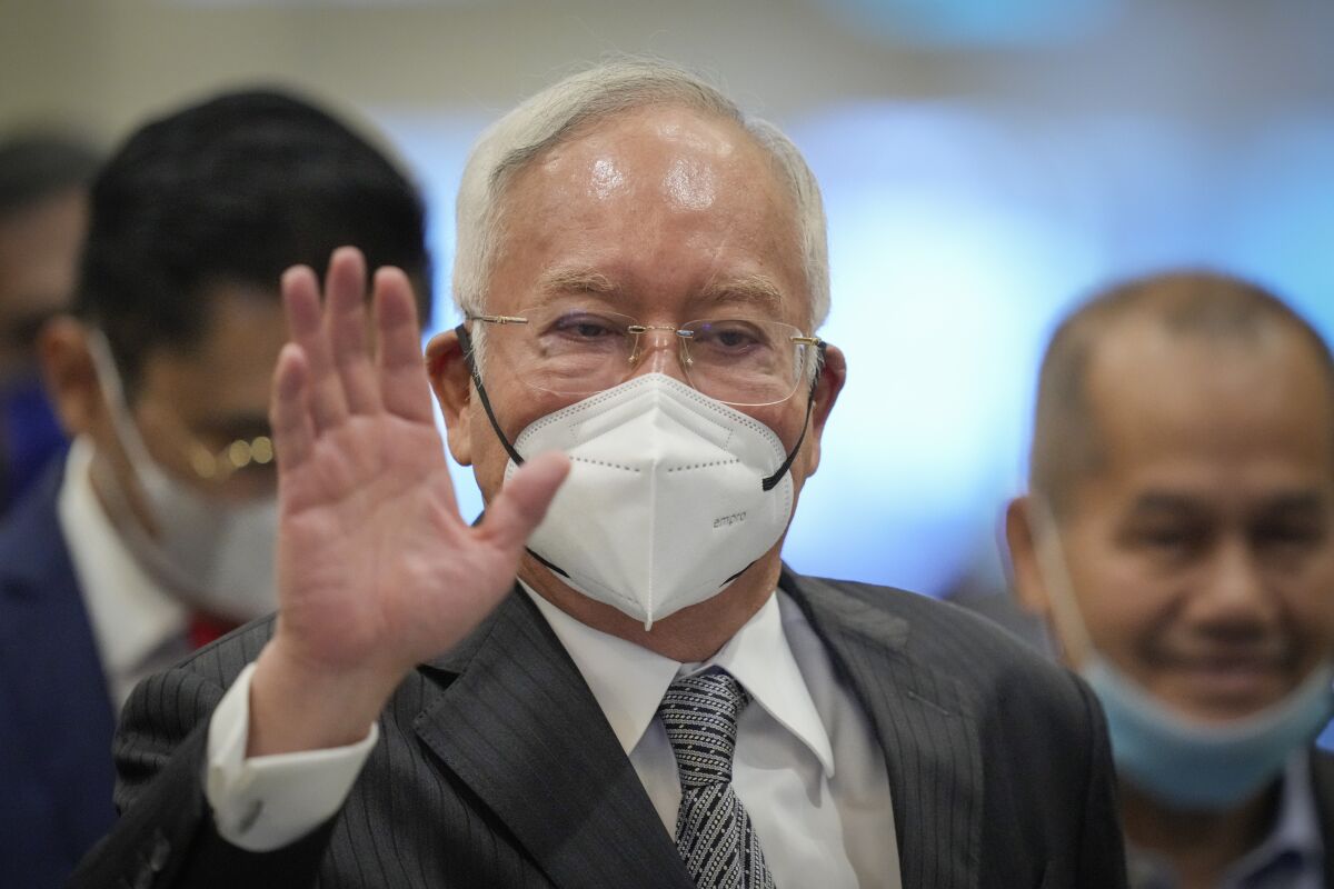 Former Malaysian Prime Minister Najib Razak, center, wearing a face mask arrives at Court of Appeal in Putrajaya, Malaysia, Tuesday, Aug. 16, 2022. Malaysia's top court Monday began hearing a final appeal by Najib to toss out his graft conviction linked to the massive looting of the 1Malaysia Development Berhad state fund. (AP Photo/Vincent Thian)