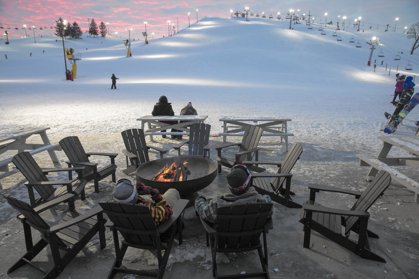 Patrons kick back and relax at the new fire pit at Wilmot Mountain, which recently opened after $13 million in renovations.
