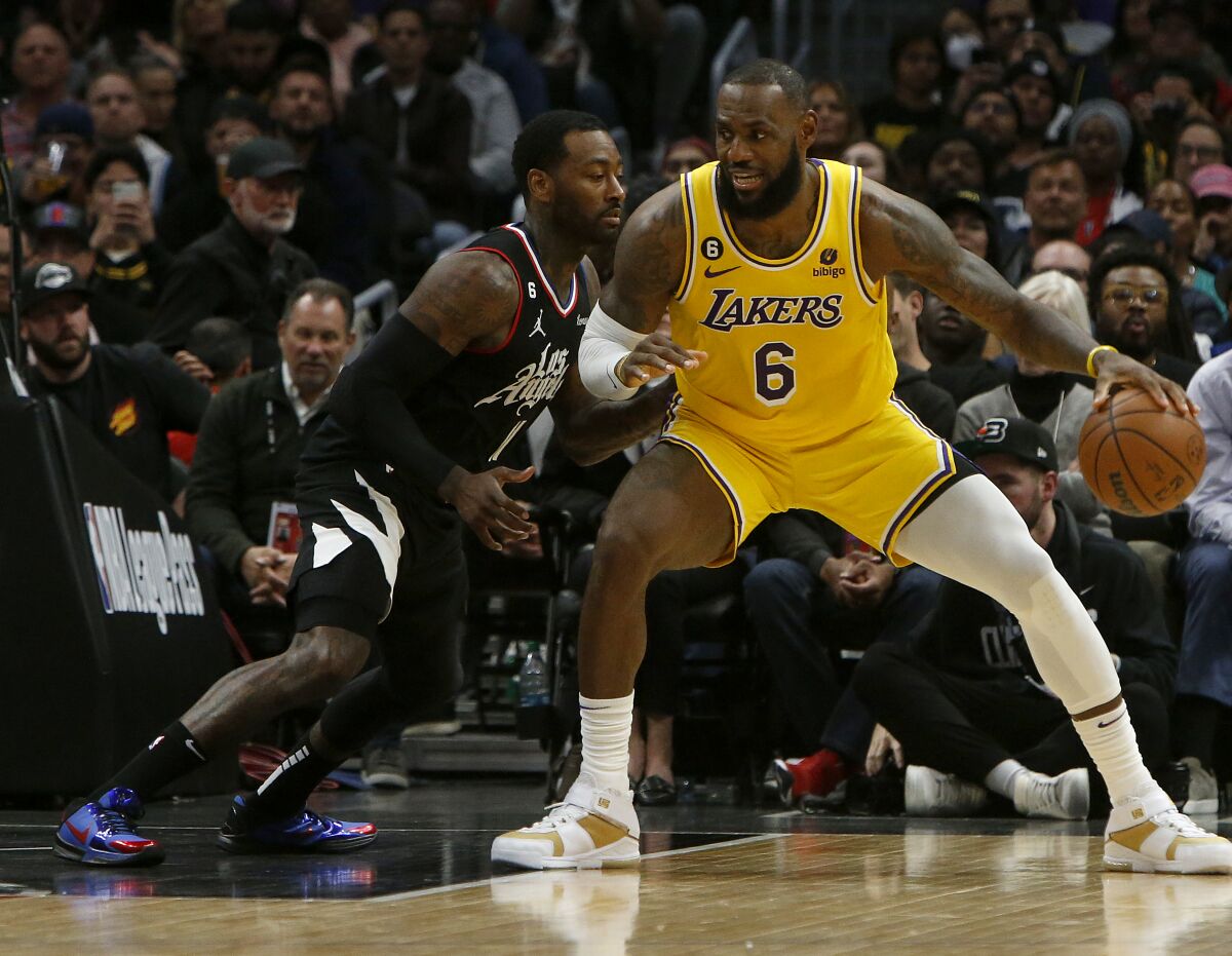 Lakers forward LeBron James works the ball inside against Clippers guard John Wall.