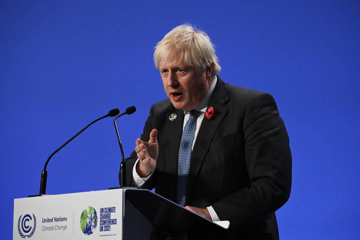 British Prime Minister Boris Johnson speaks at a lectern with a U.N. Climate Change sign on the front 