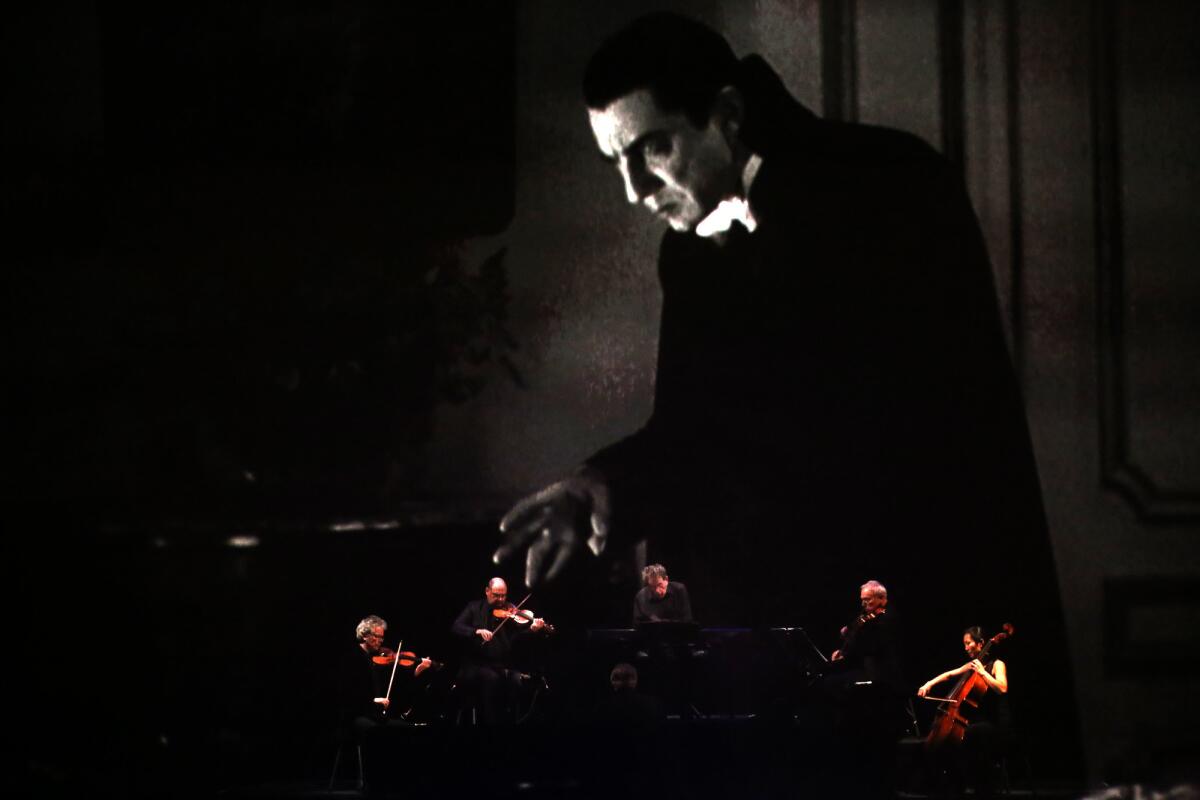 Glass and the Kronos Quartet perform behind a scrim as Bela Lugosi fills the screen at the Ace.
