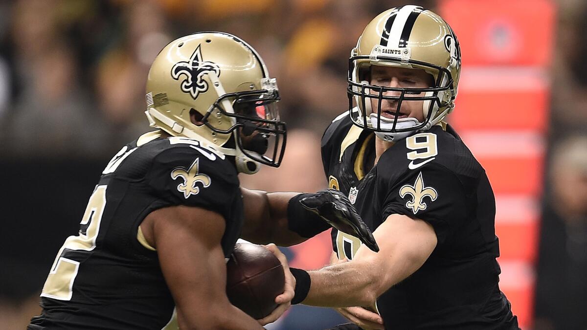 New Orleans quarterback Drew Brees, right, hands off the ball to running back Mark Ingram during a win over the Green Bay Packers on Sunday.