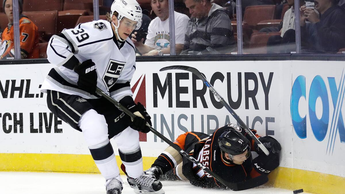 The Kings' Adrian Kempe, left, moves the puck past the Ducks' Jacob Larsson on Oct. 2.