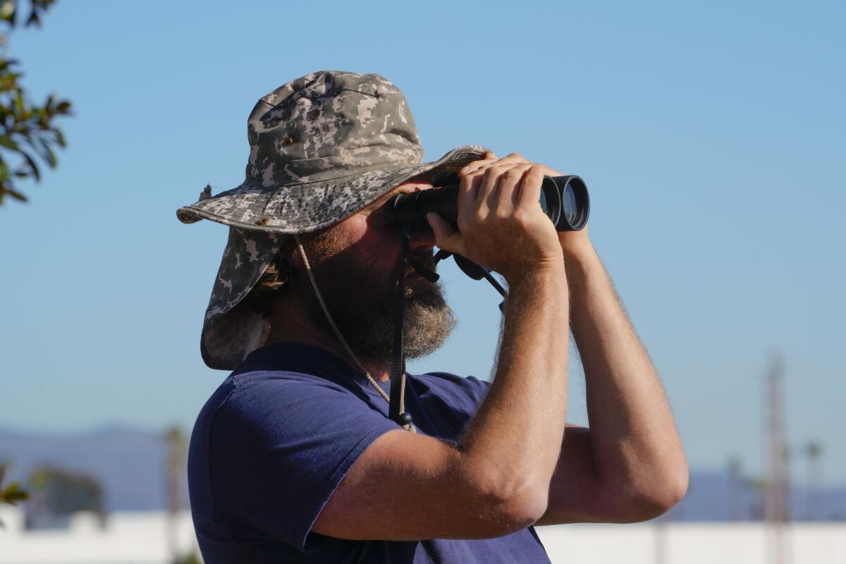 Matt Sadowski peers through binoculars