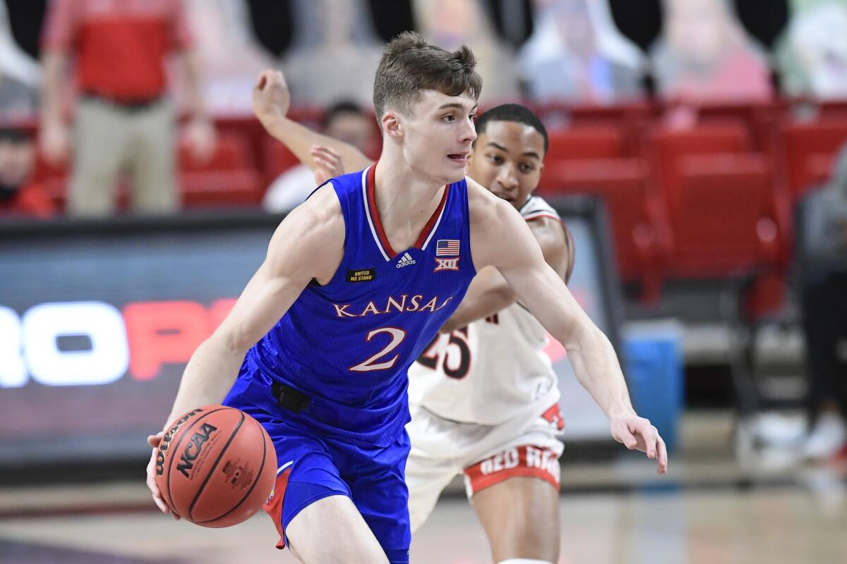 Kansas' Christian Braun dribbles the ball down the court.