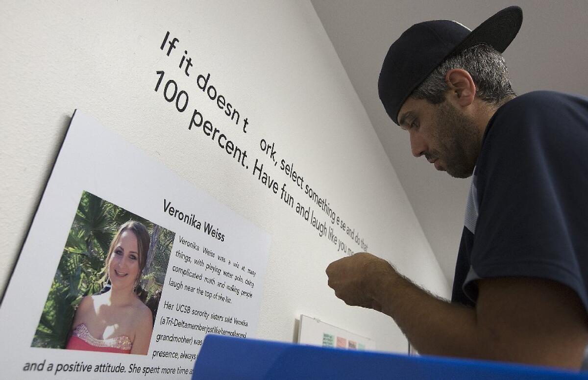 John Picarelli, an employee of a local printing company, puts the finishing touches on a display remembering Veronika Weiss, a victim in last year's Isla Vista shooting rampage.